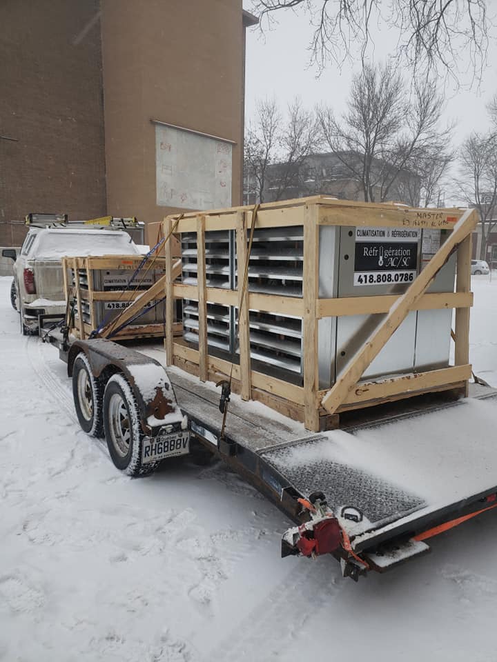 Une remorque avec une caisse dessus est posée dans la neige.