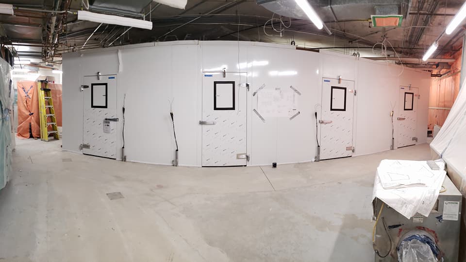 Une grande pièce avec beaucoup de murs et de portes blancs.