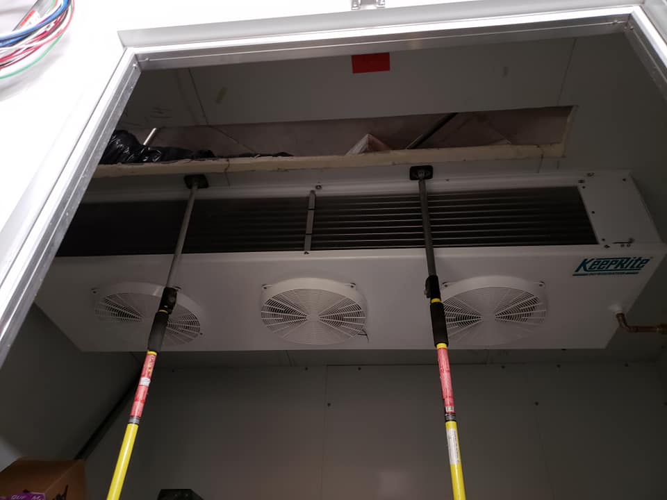 Une pièce avec un ventilateur de plafond et une porte.