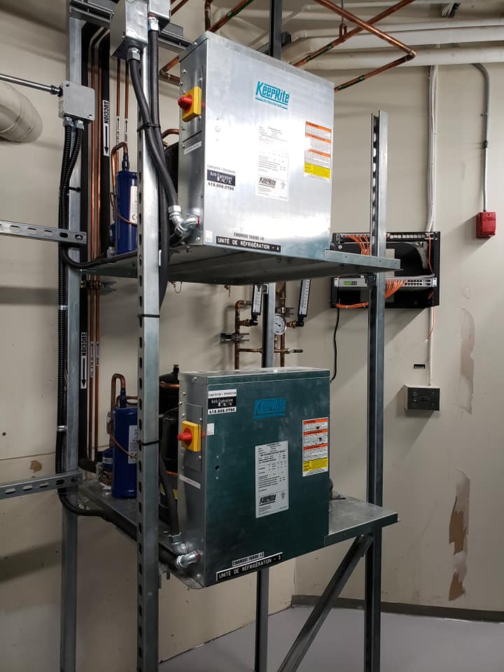 Une pièce avec beaucoup d'équipement électrique et une alarme incendie au mur.