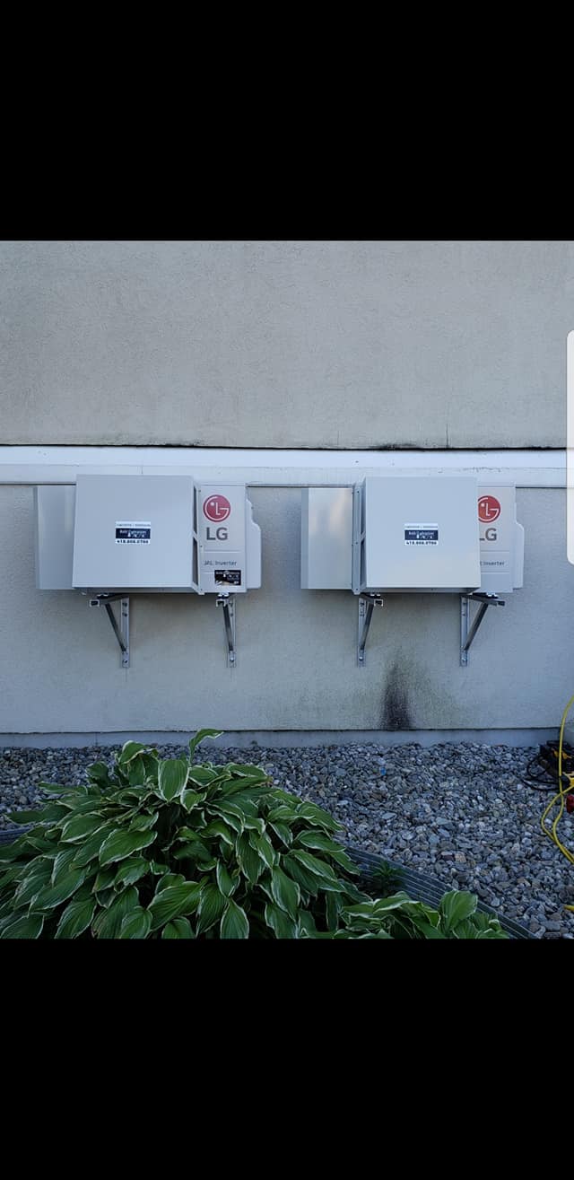 Deux panneaux solaires sont montés sur le côté d'un bâtiment.