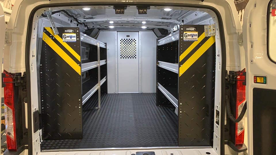 L'intérieur d'une camionnette blanche avec des étagères et une fenêtre.