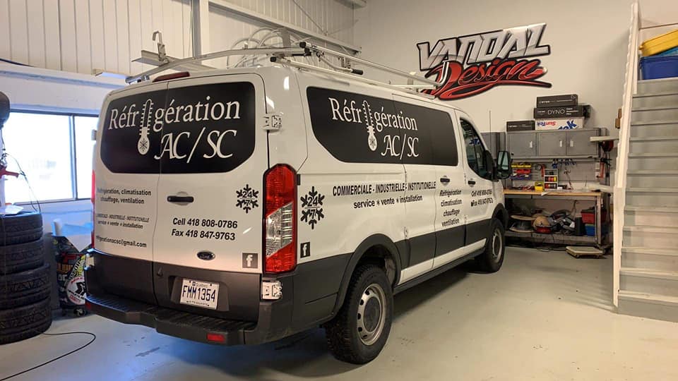 Une camionnette blanche est garée dans un garage.