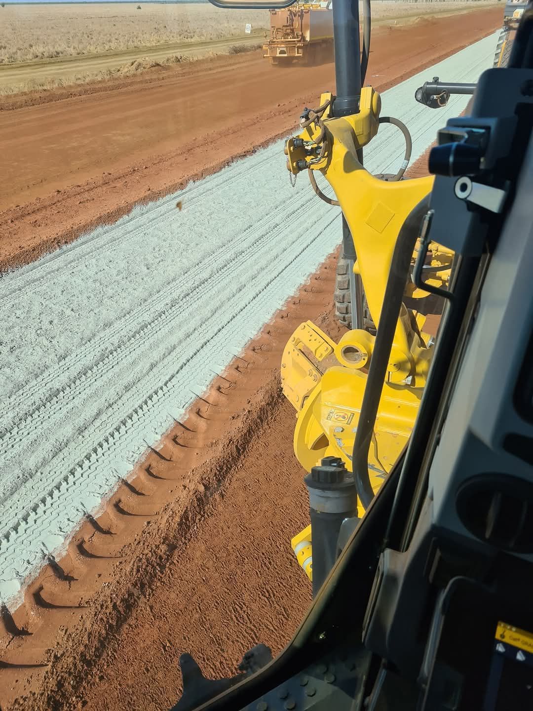 Yellow road roller in an outdoor setting.