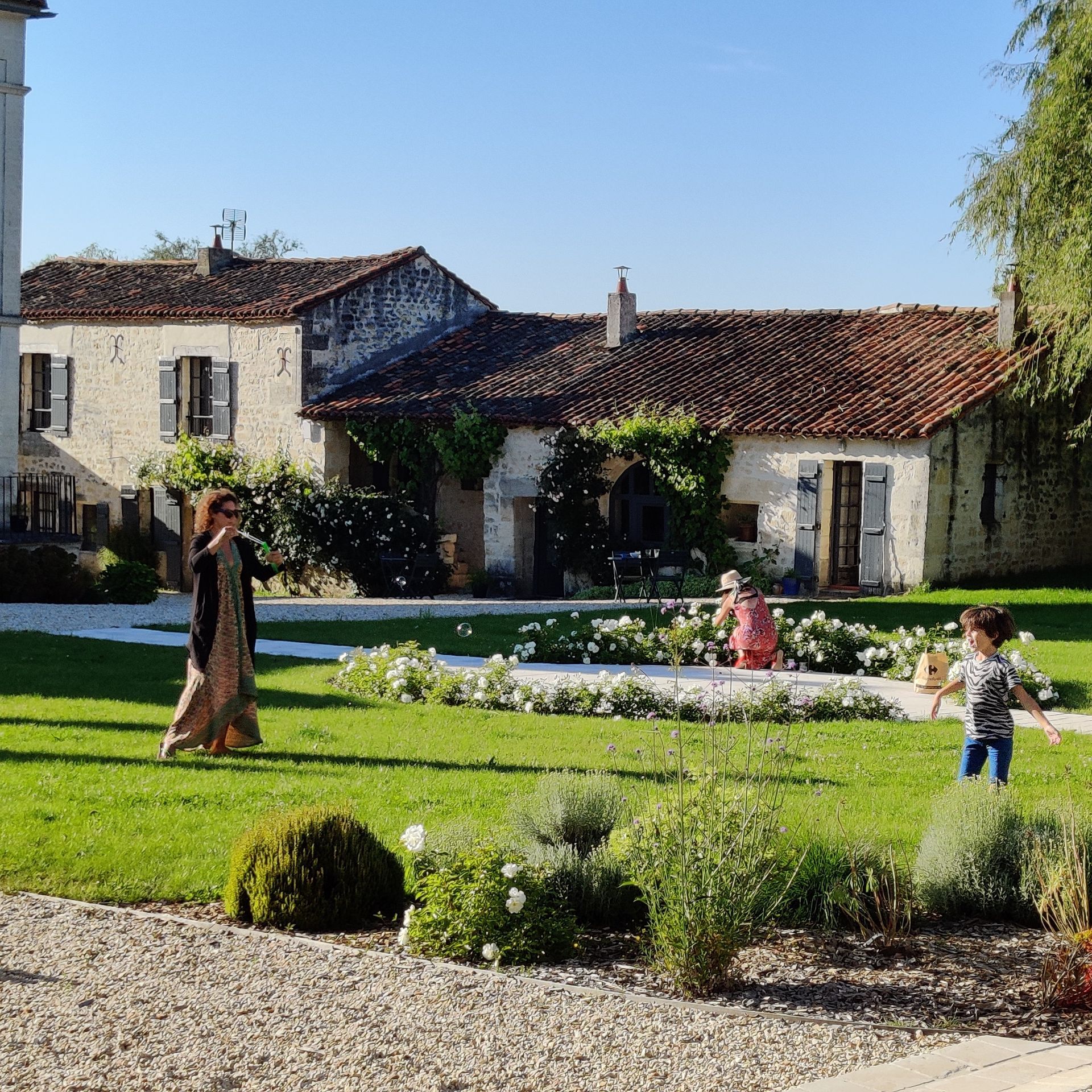 Un groupe de personnes marche dans une zone herbeuse devant une maison