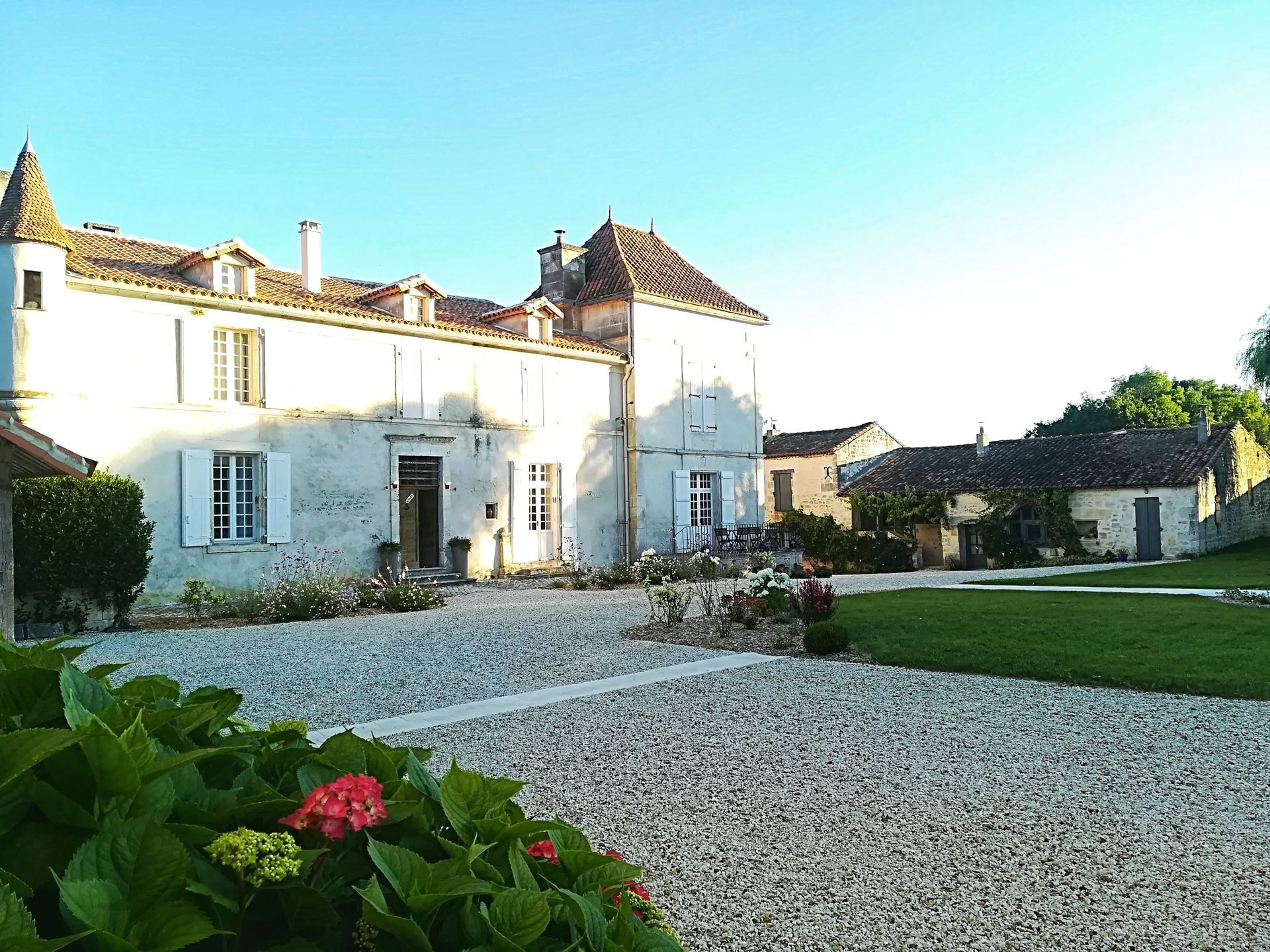 Un grand bâtiment blanc avec une allée de gravier devant.