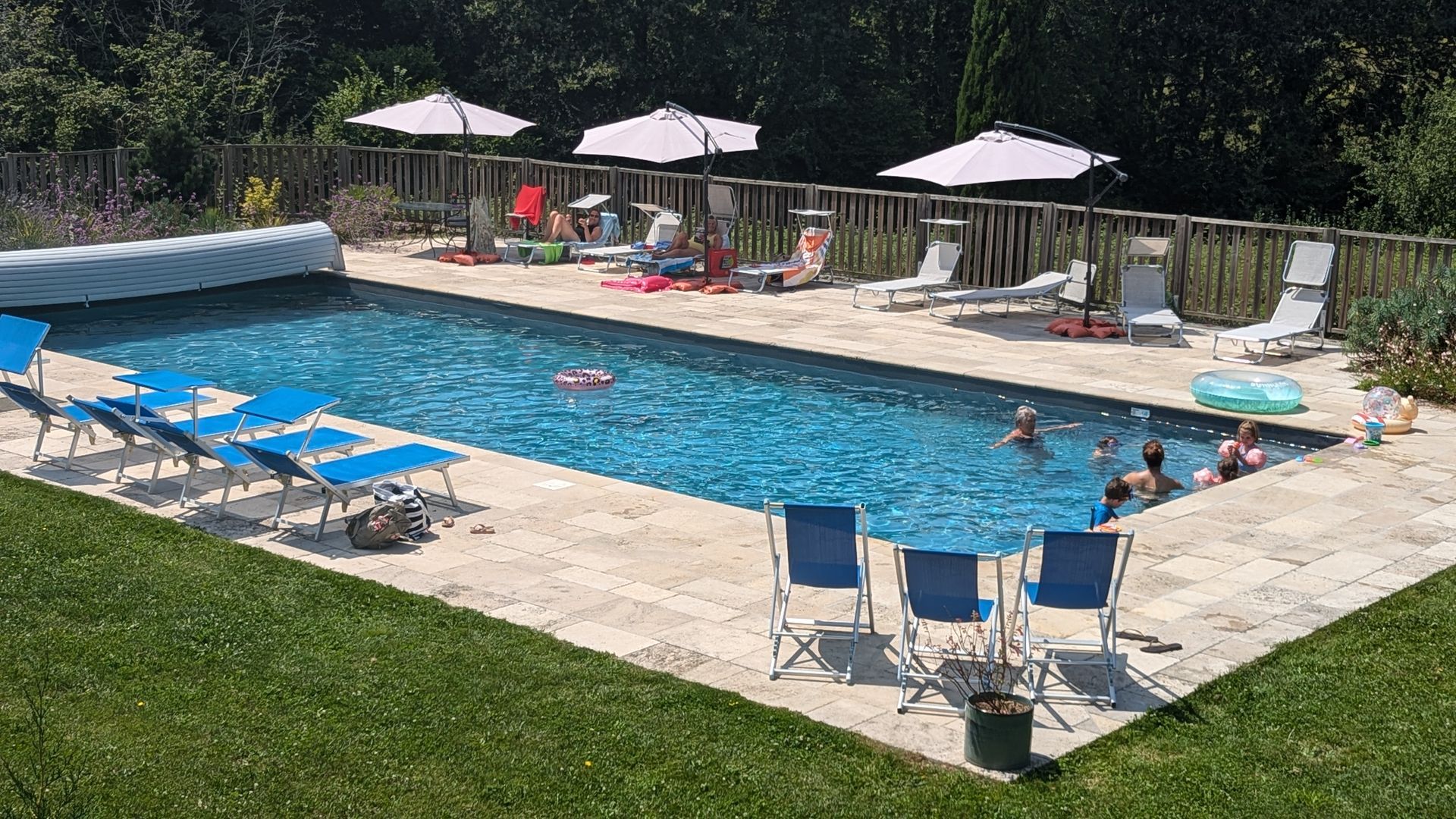 Une grande piscine entourée de transats et parasols