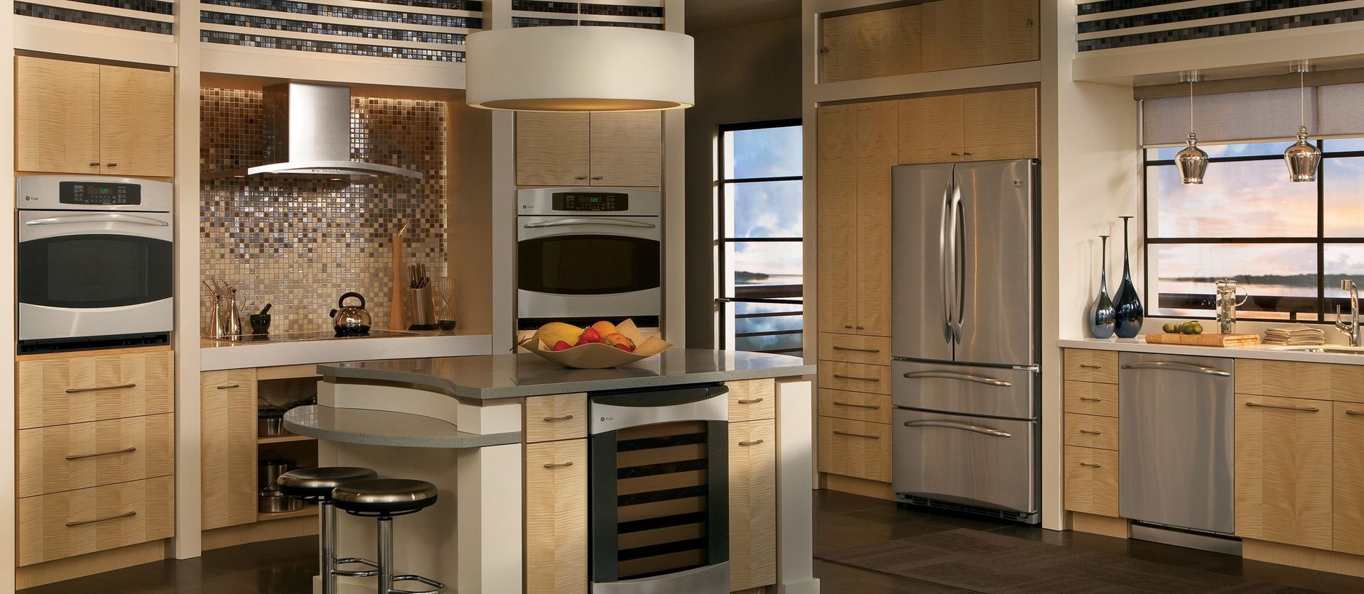 Modern kitchen with light wood cabinets, stainless steel appliances, a central island, and a mosaic backsplash.