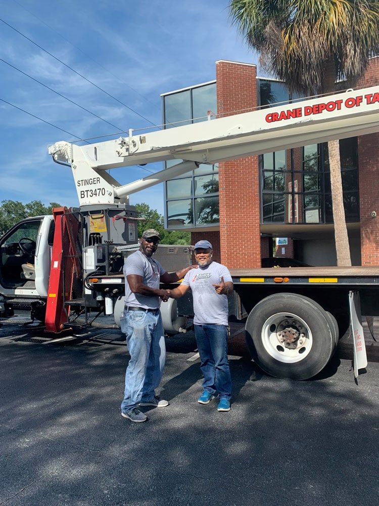 Workers Standing Next to a Mobile Crane