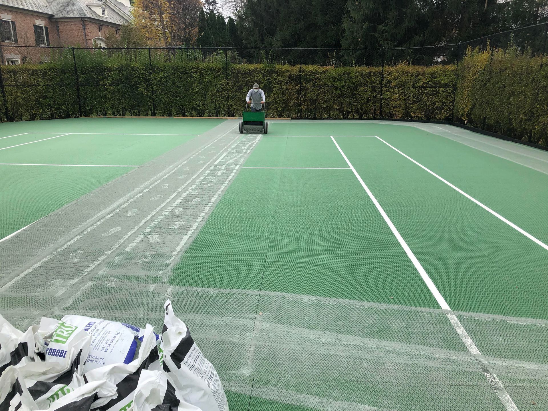 a man is cleaning a tennis court with a machine