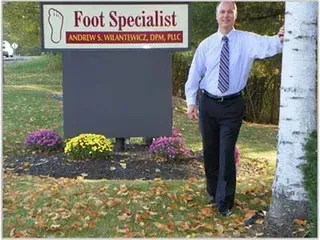 Person in gloves massaging another person's foot, indoors.