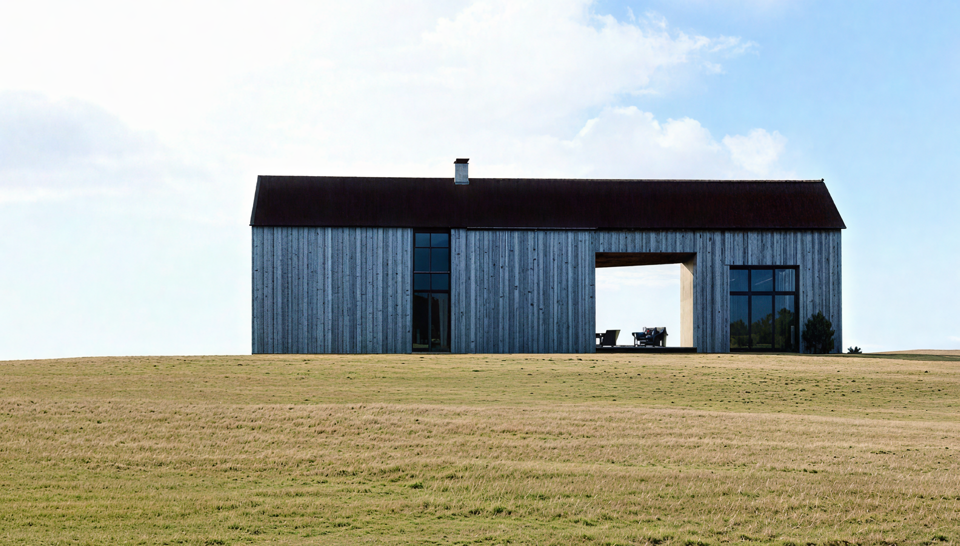 A large white house with a pergola and stairs is lit up at night.