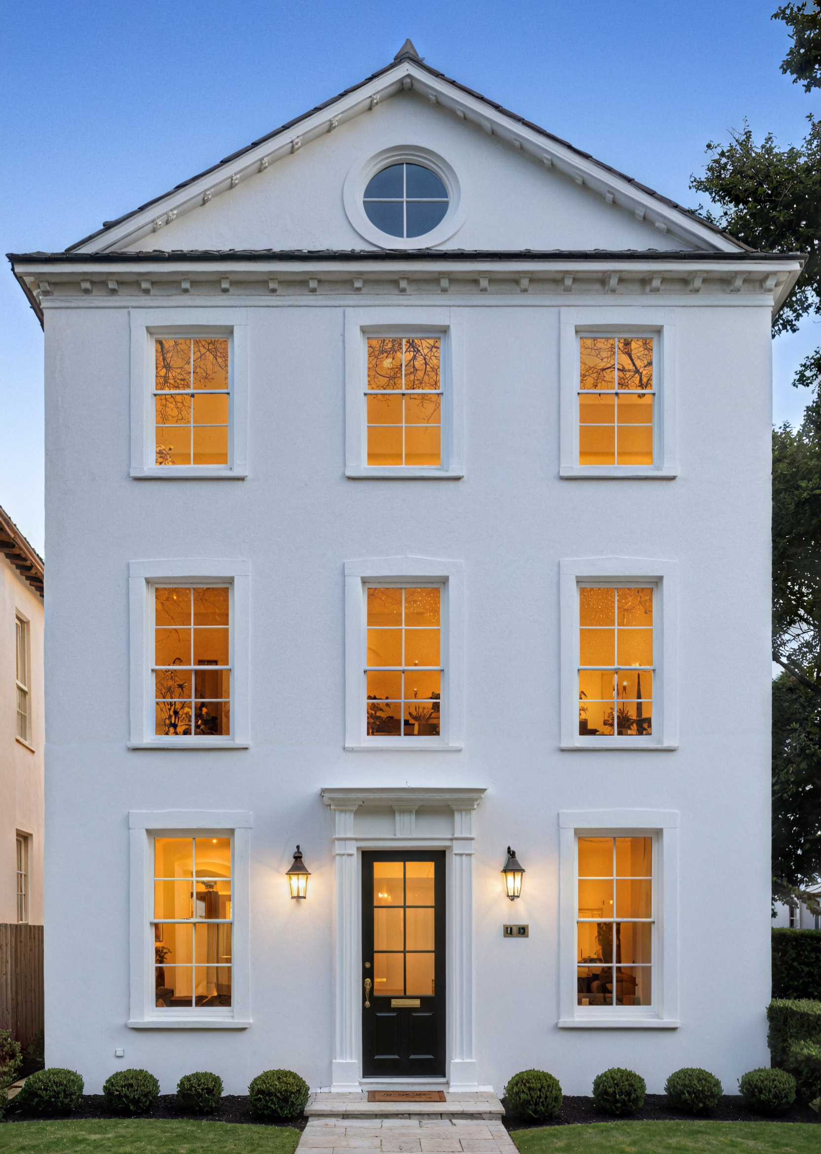 A modern house with a red car parked in front of it.