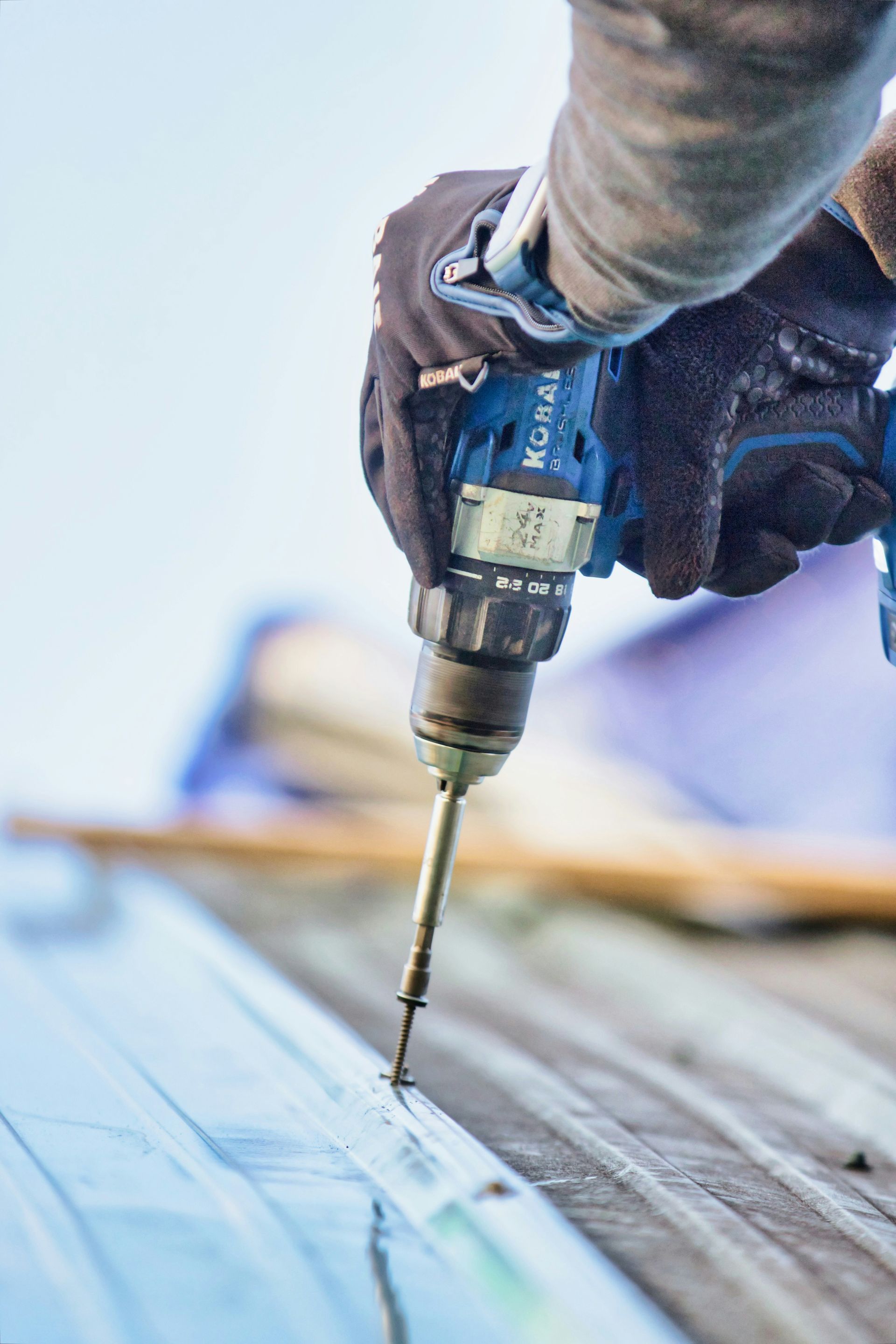 A person is using a drill to drill a hole in a piece of wood.