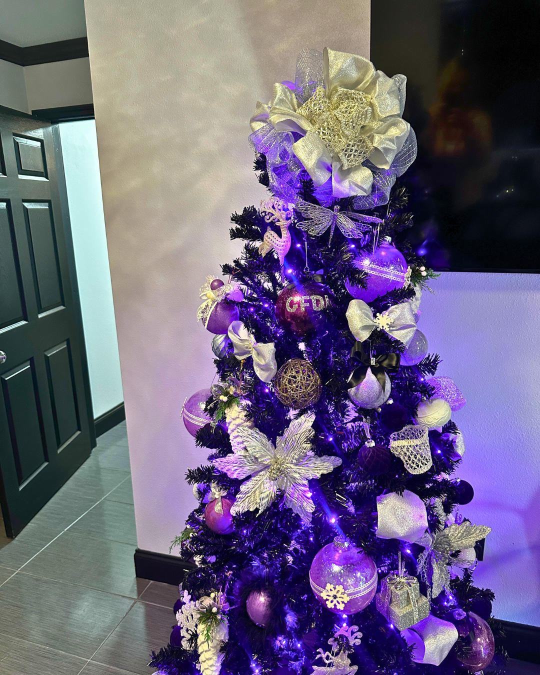 Purple Christmas tree with ornaments and decorations.