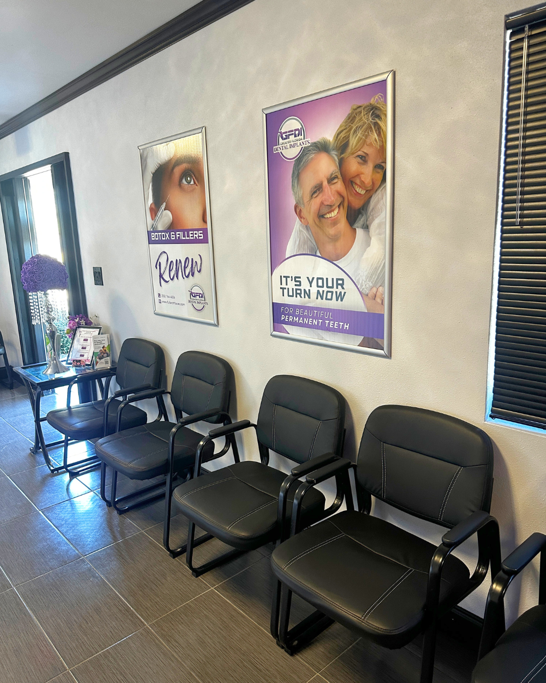 Waiting room with black chairs and posters on the wall.