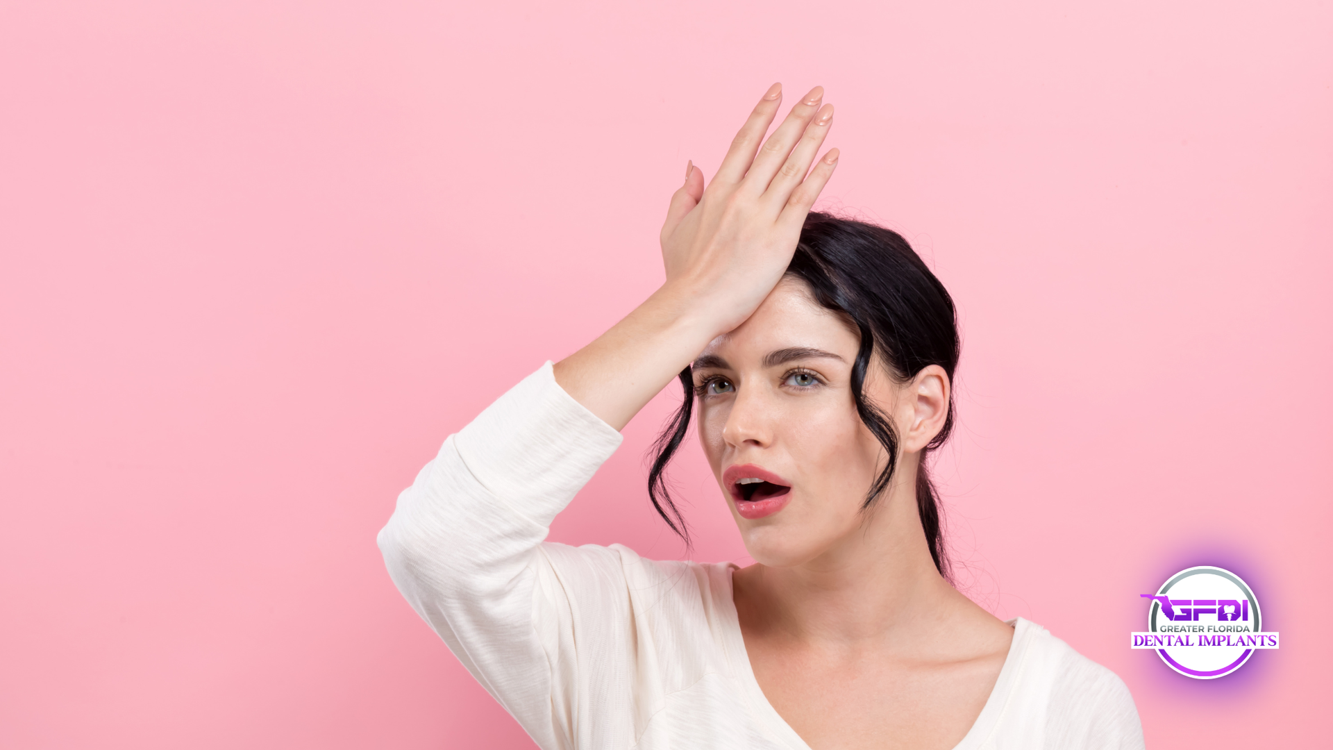 Woman with hand on forehead, looking surprised, against a pink background.