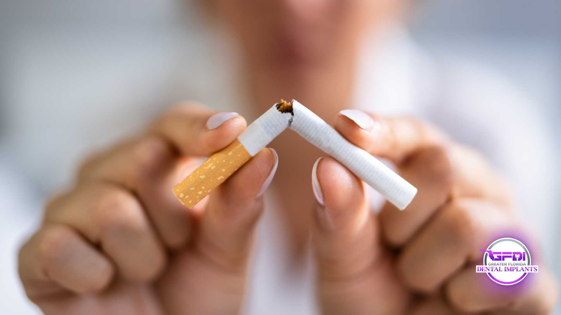 Person breaking a cigarette in half, signifying quitting smoking.