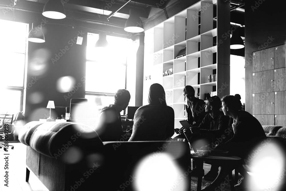 a group of people are sitting at tables in a room .