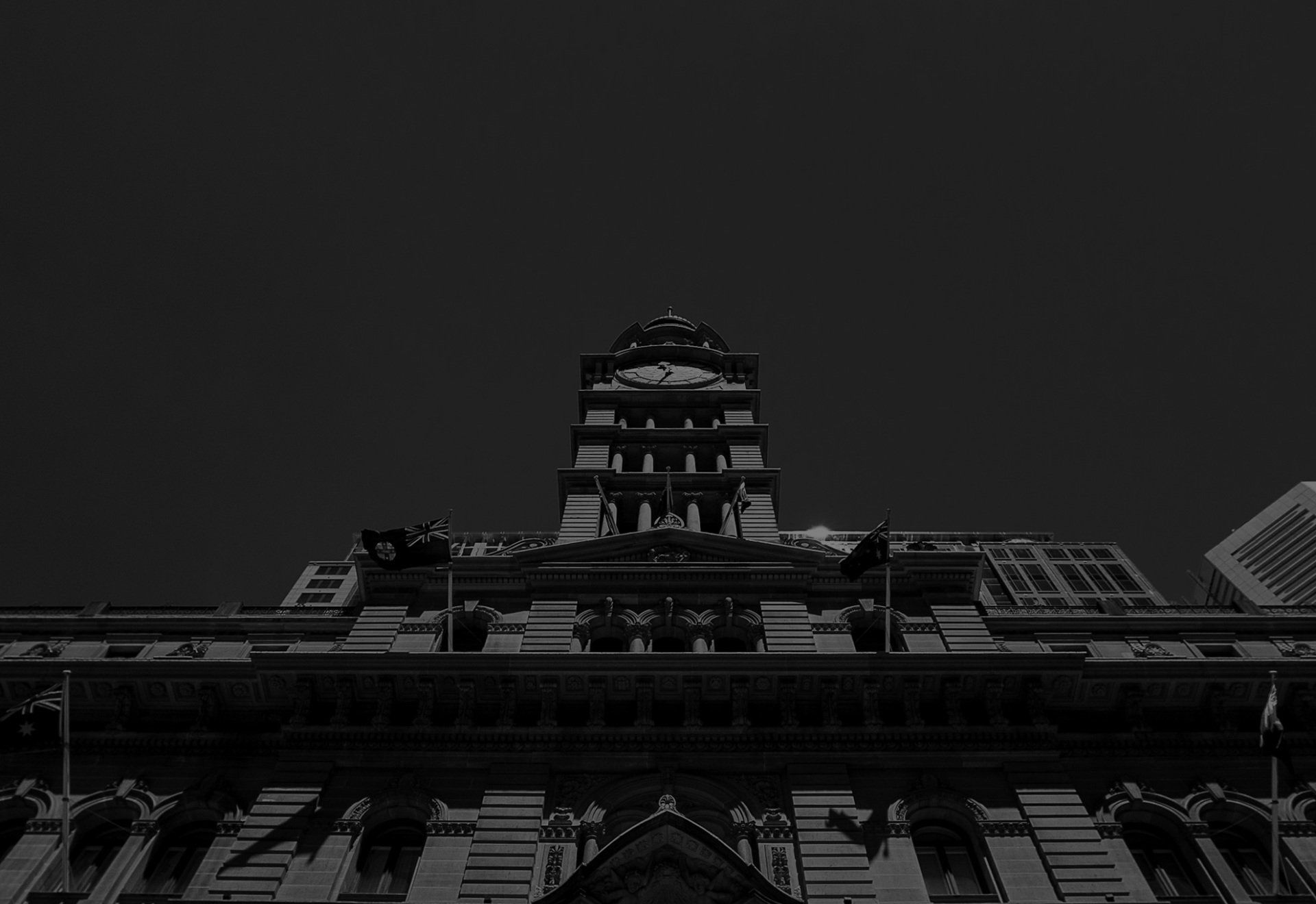 A black and white photo of a large building with a clock tower on top of it.