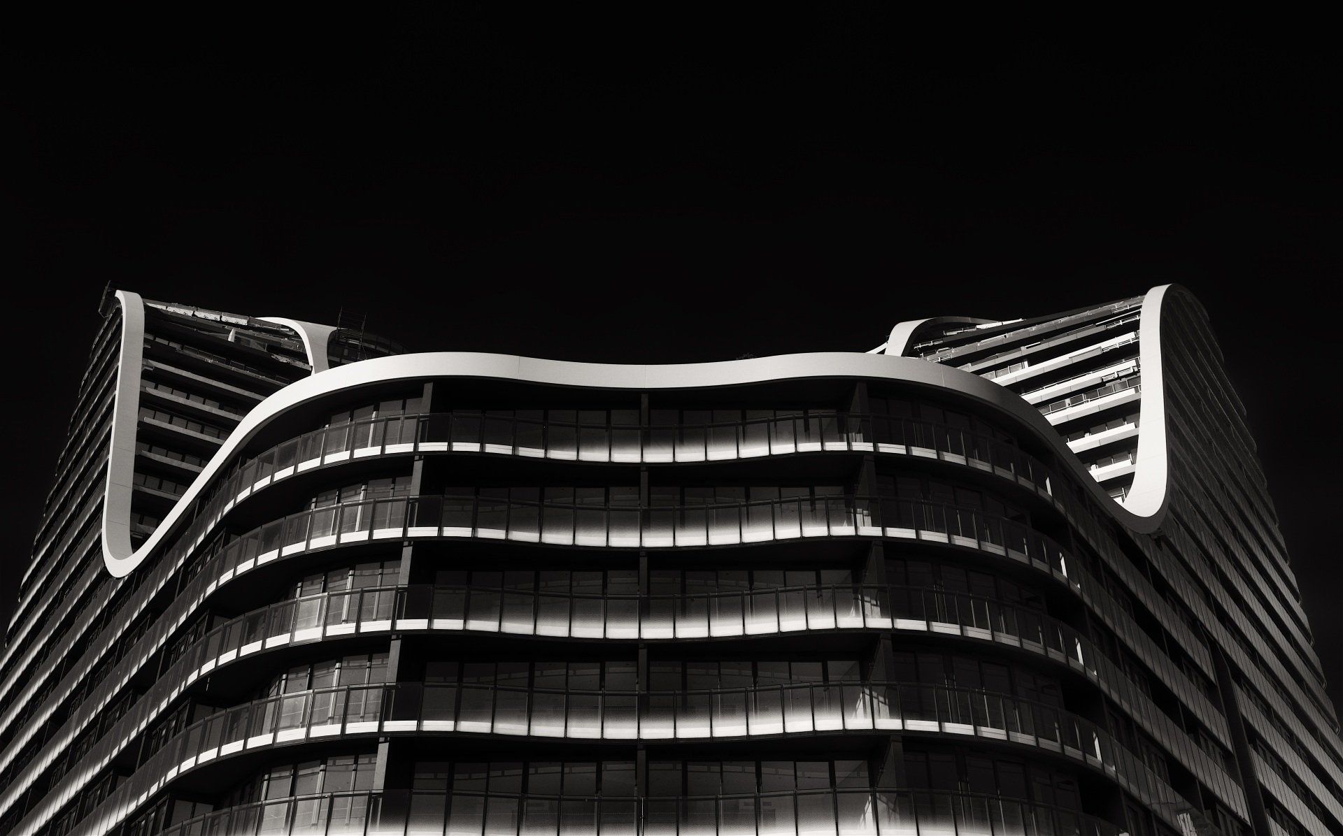 A black and white photo of a tall building at night