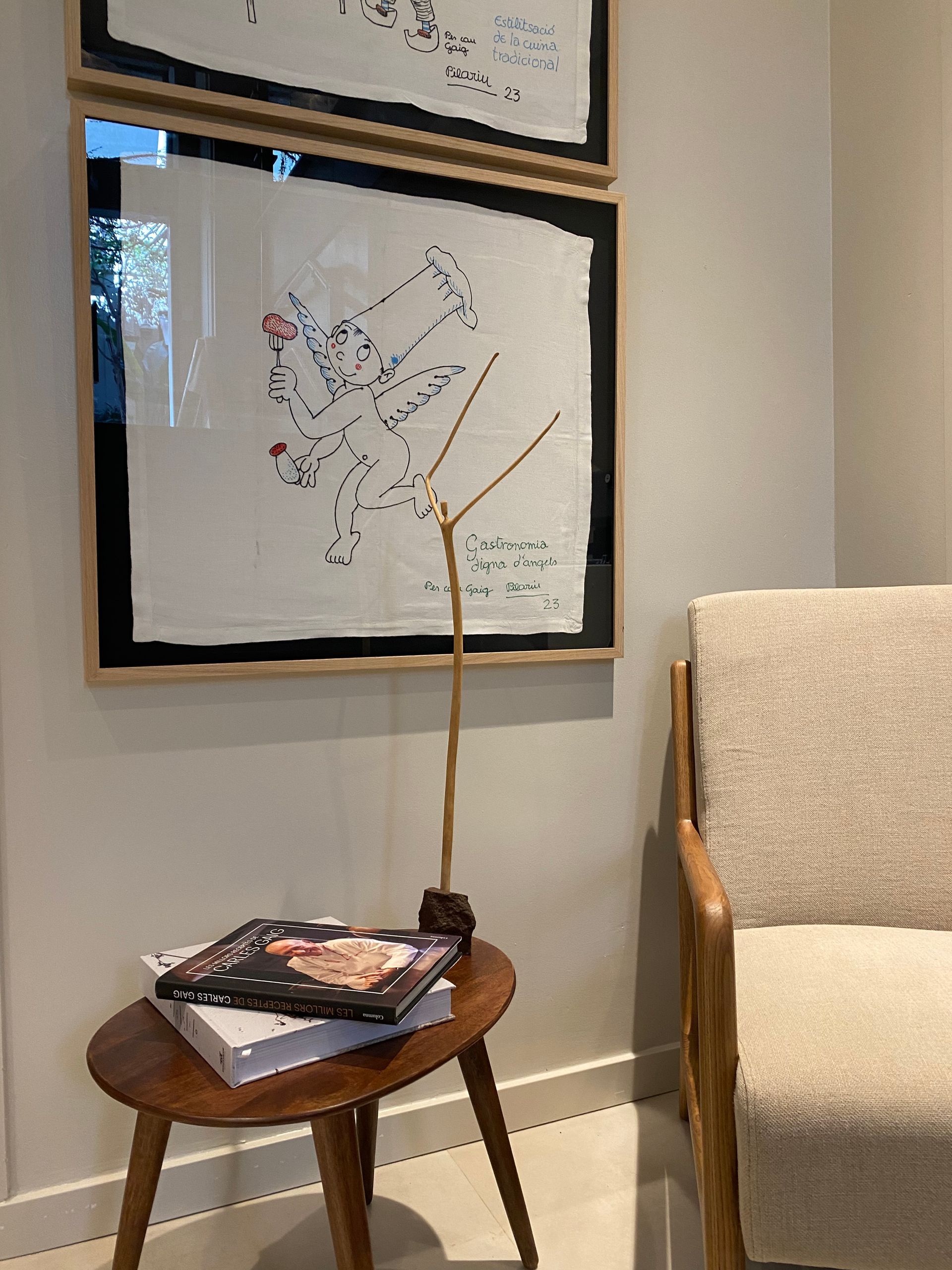 Una silla y una mesa en una habitación con cuadros en la pared.