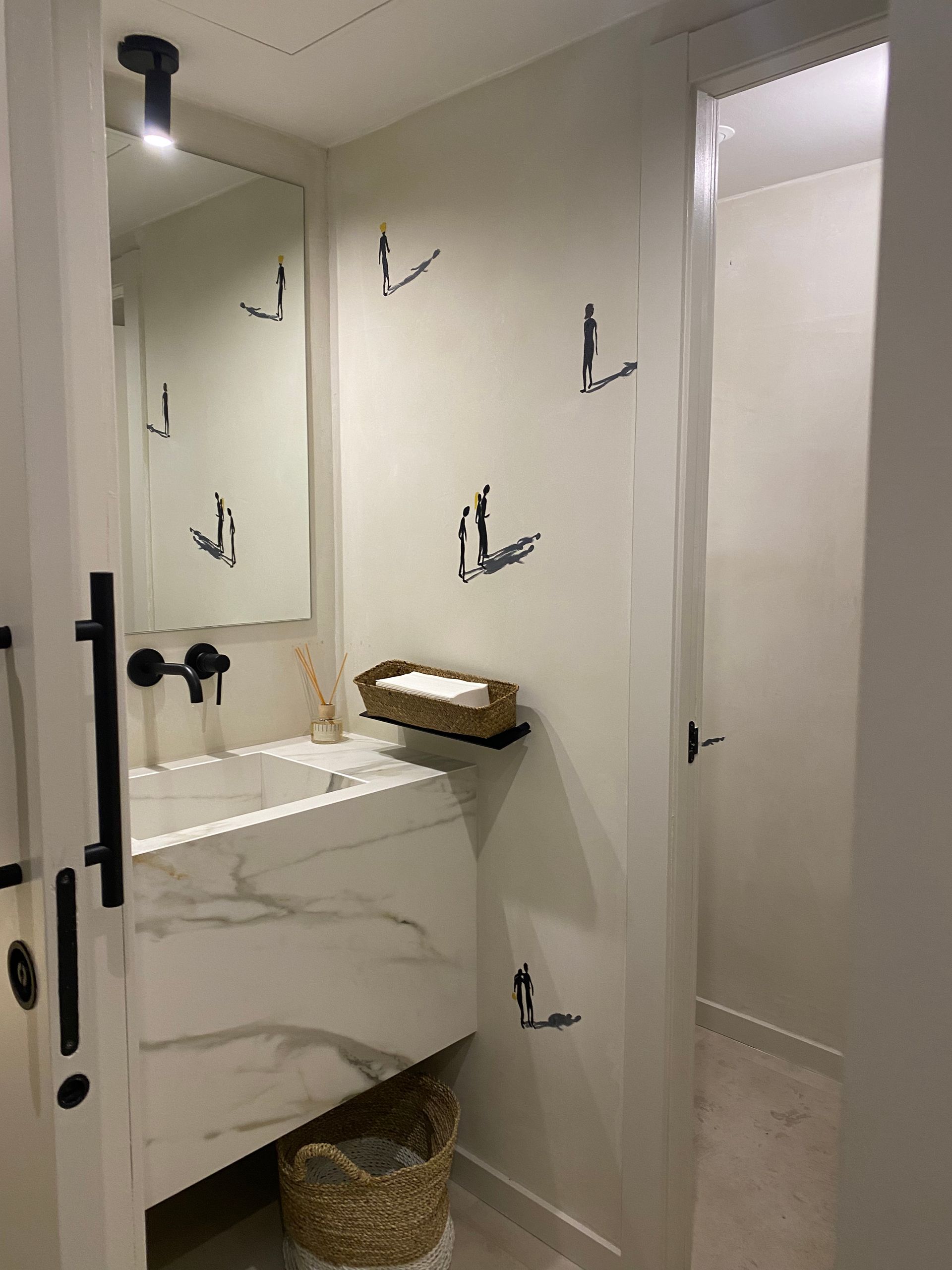 Un baño con lavabo, espejo y puerta.