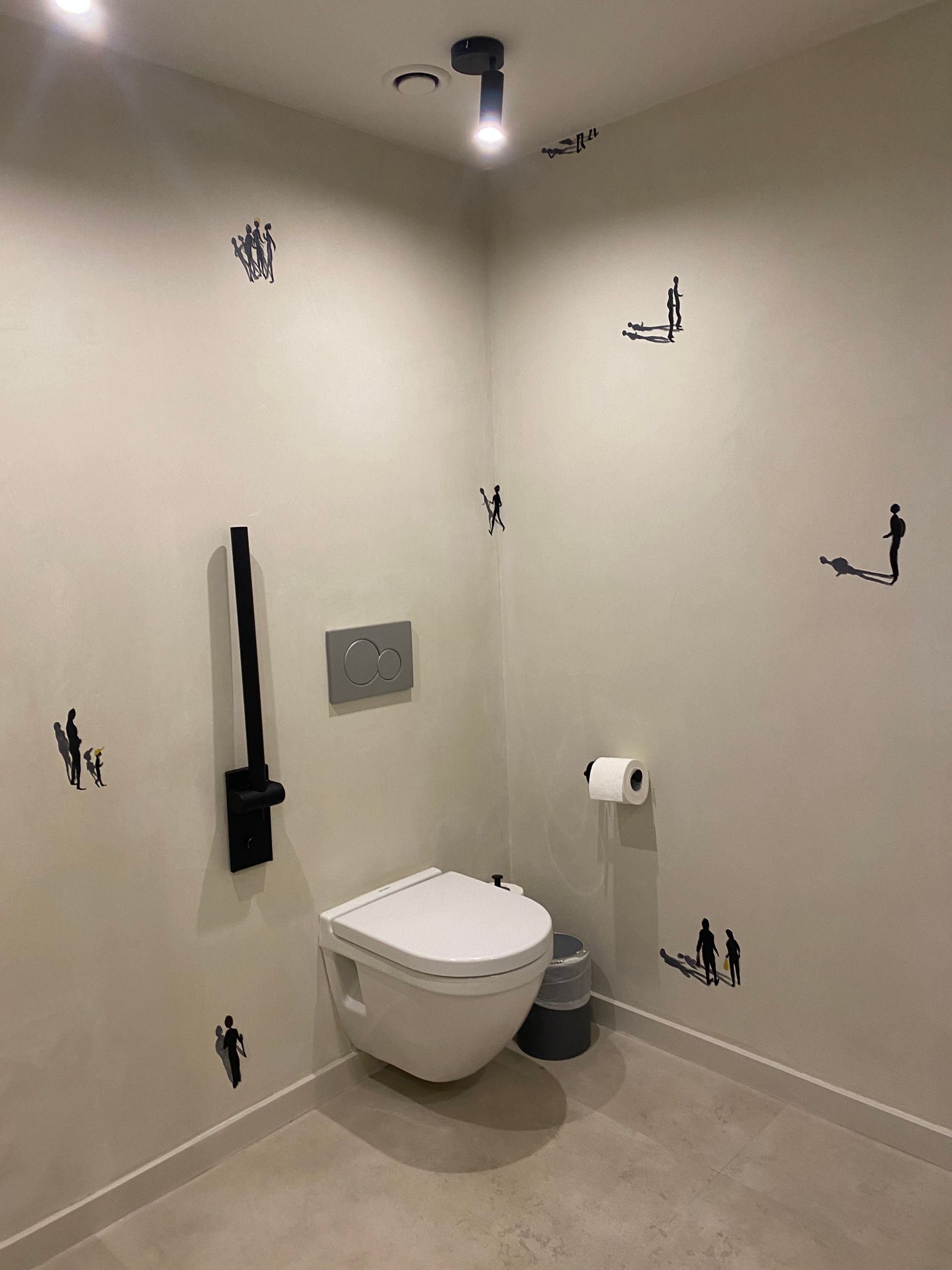 Un baño con inodoro y dispensador de toallas de papel.