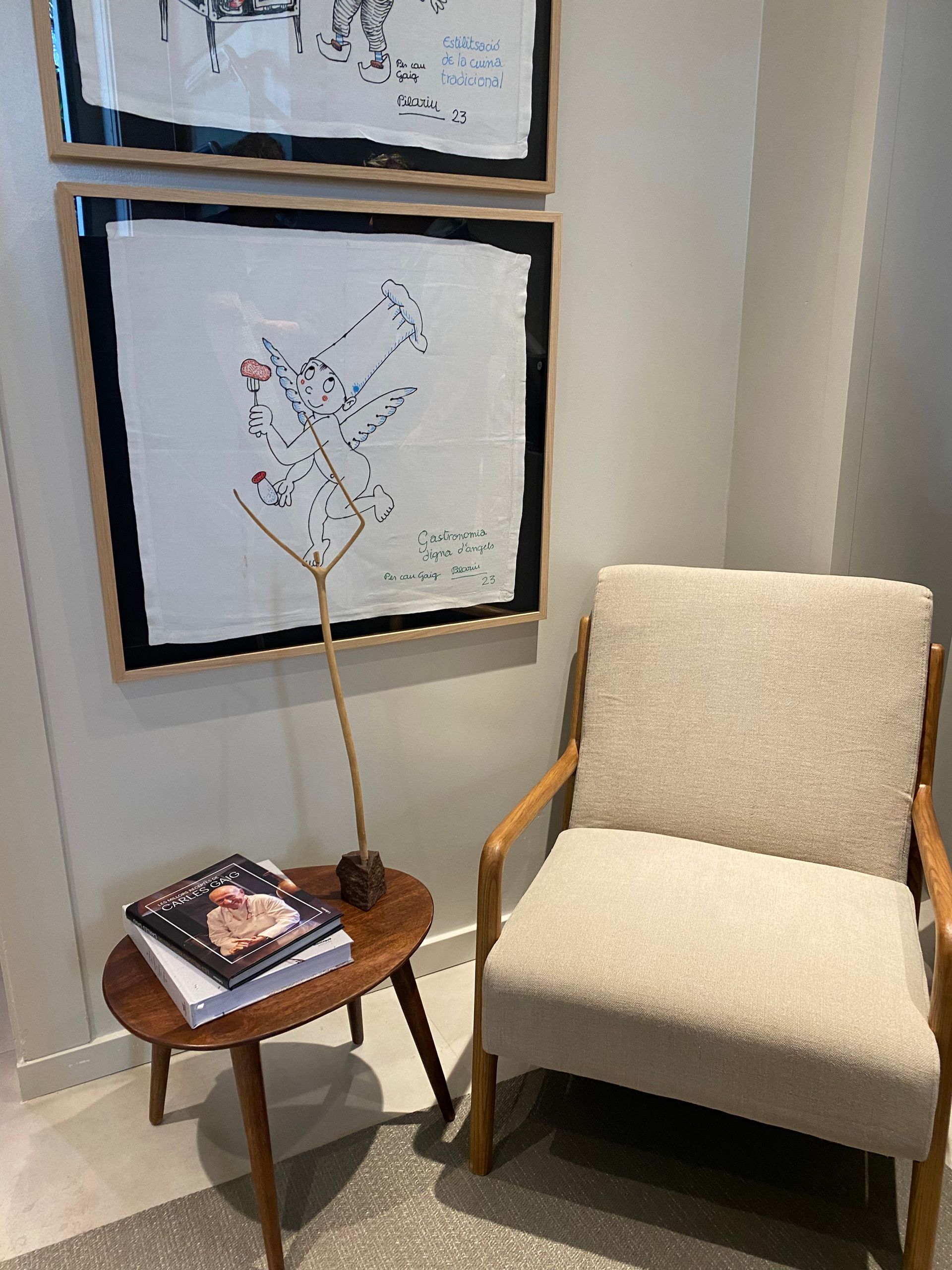 Una silla y una mesa en una habitación con cuadros en la pared.