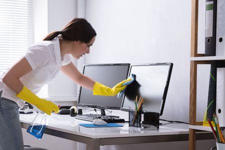 woman cleaning computer screens