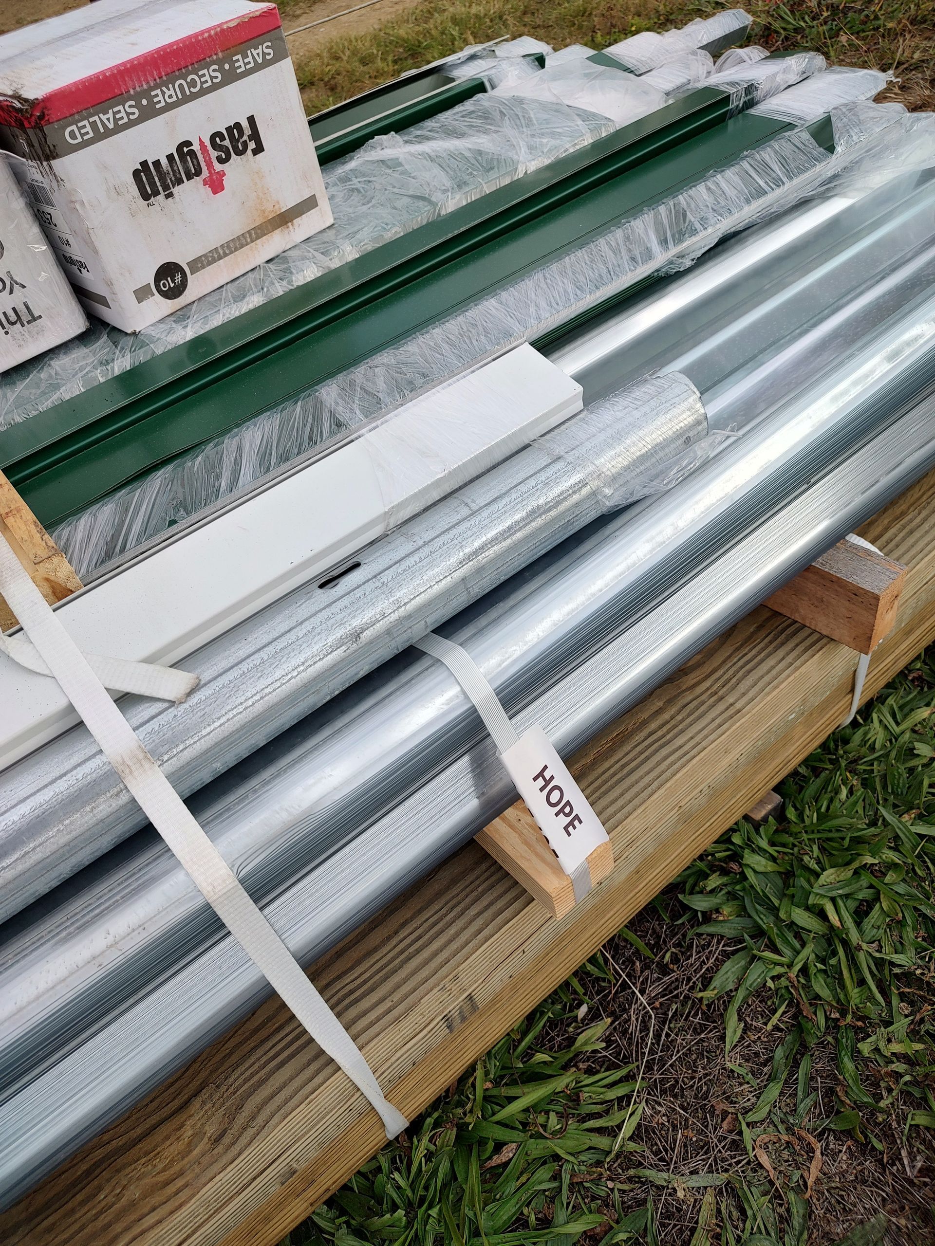 A bunch of metal pipes are sitting on top of a wooden pallet.
