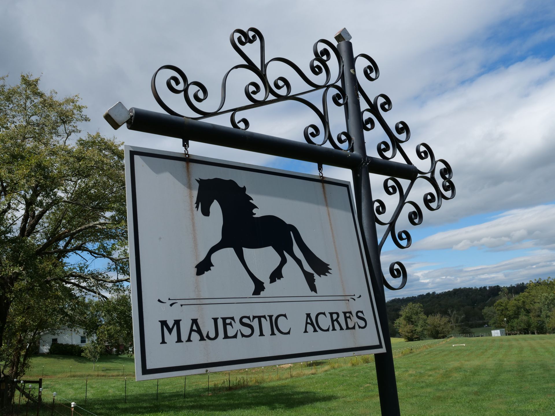 A sign for majestic acres with a horse on it