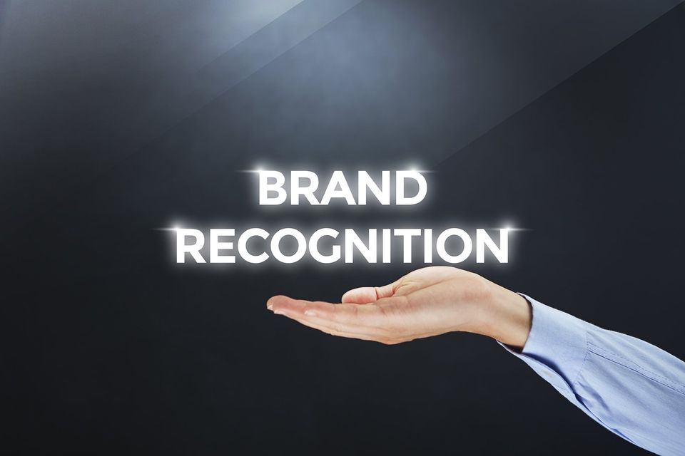 a hand is holding up the word brand recognition