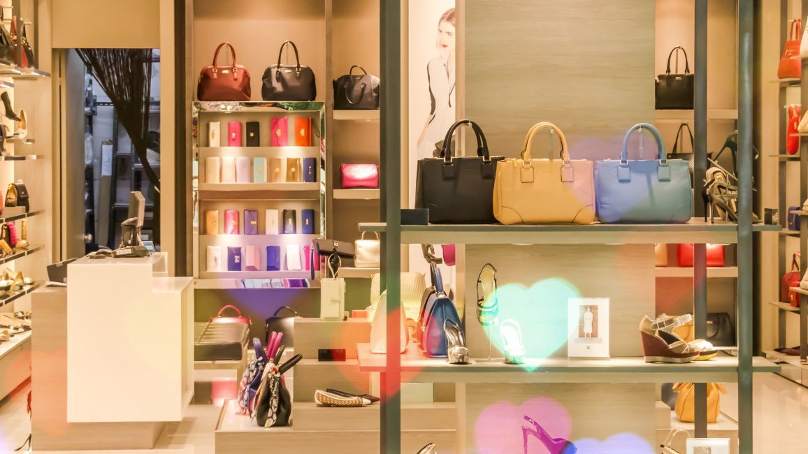 a store filled with lots of handbags and shoes .