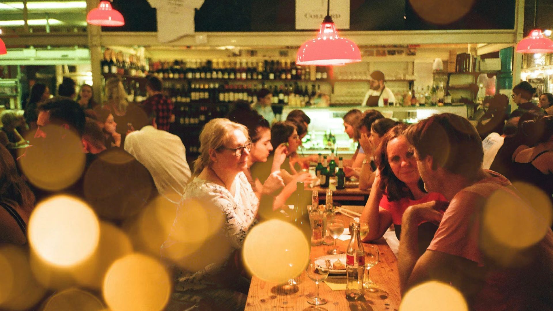 A group of people are sitting at a long table in a restaurant.