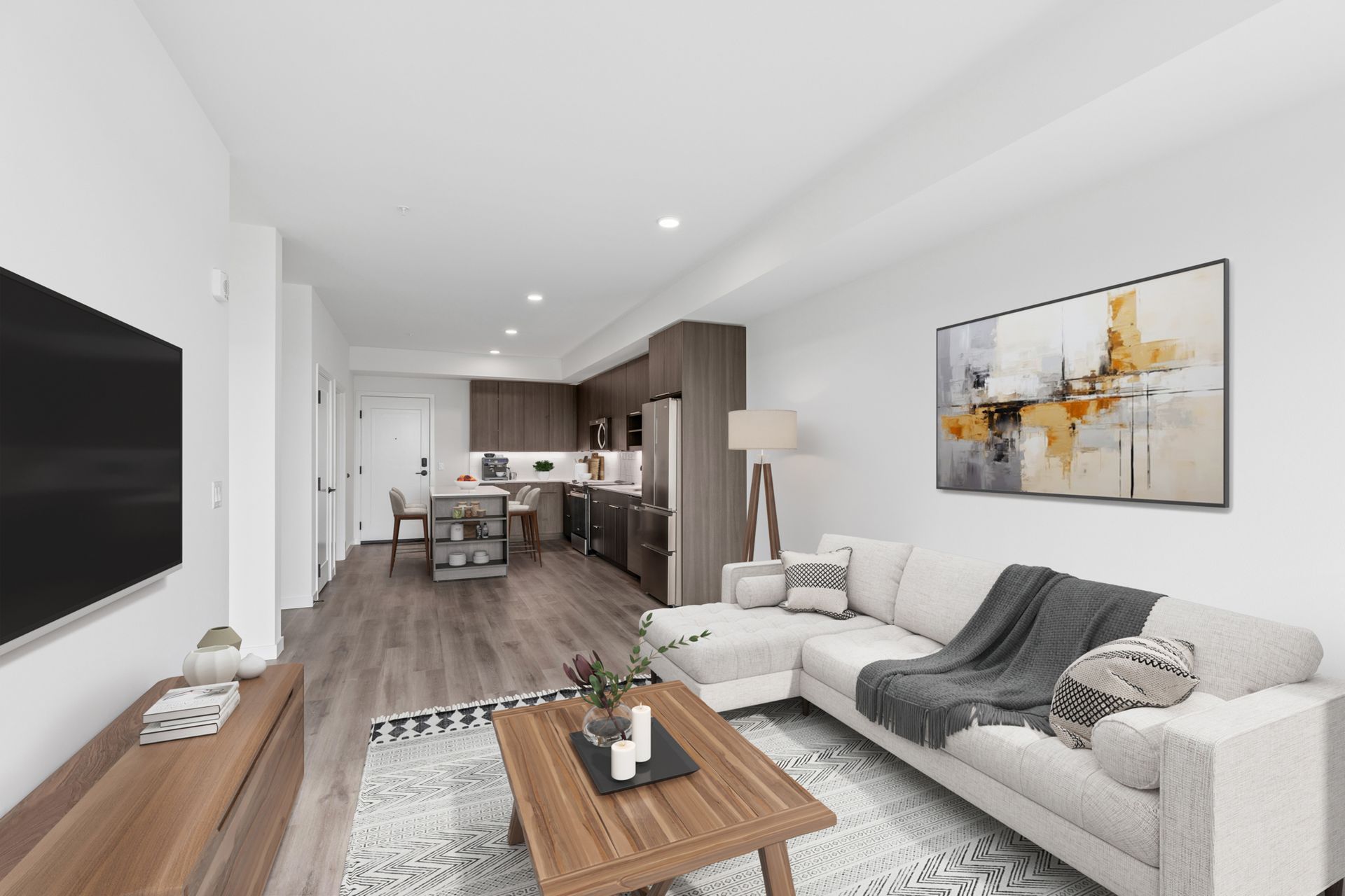 Modern open-concept living room with gray sofa, wooden coffee table, and kitchen in the background