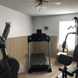 Home gym with treadmill, elliptical, and weight machine.
