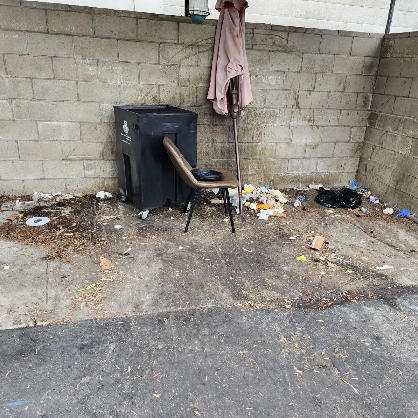 A chair is sitting on the ground in front of a brick wall