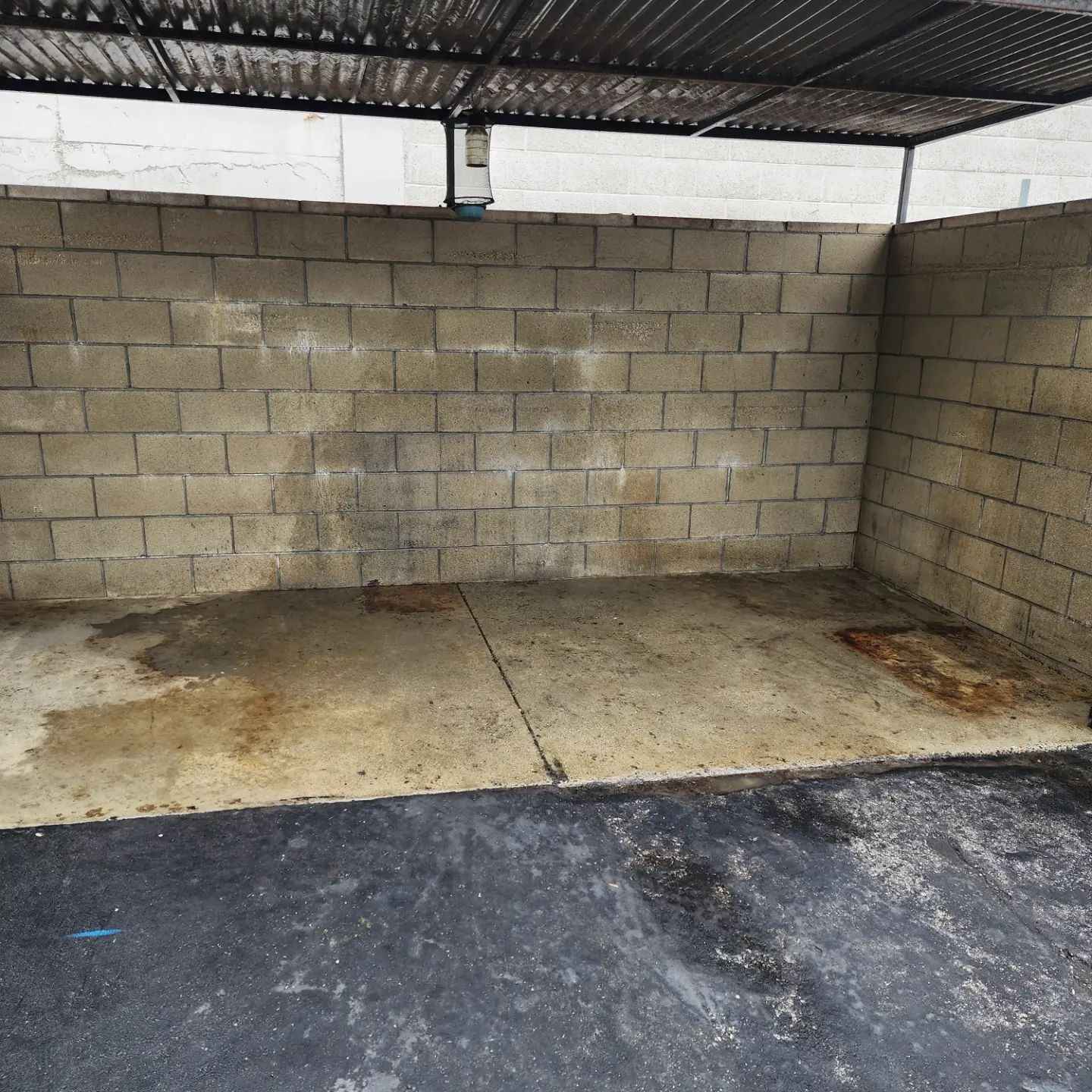 An empty room with brick walls and a metal roof