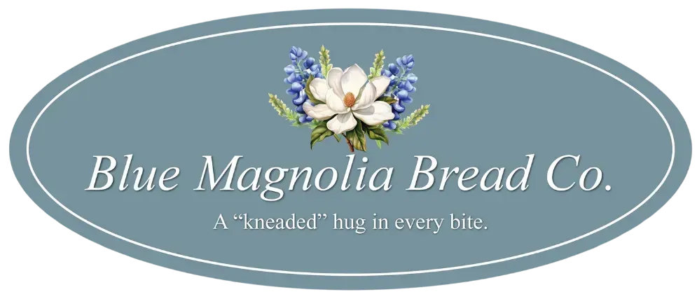 Logo for Blue Magnolia Bread Co. with a floral design, in an oval shape and light blue color.