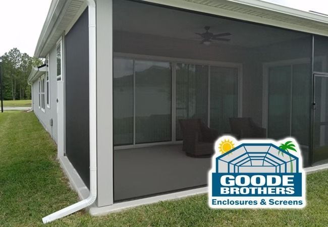 A screened-in patio area of a house with a Goode Brothers Enclosures & Screens logo overlay.