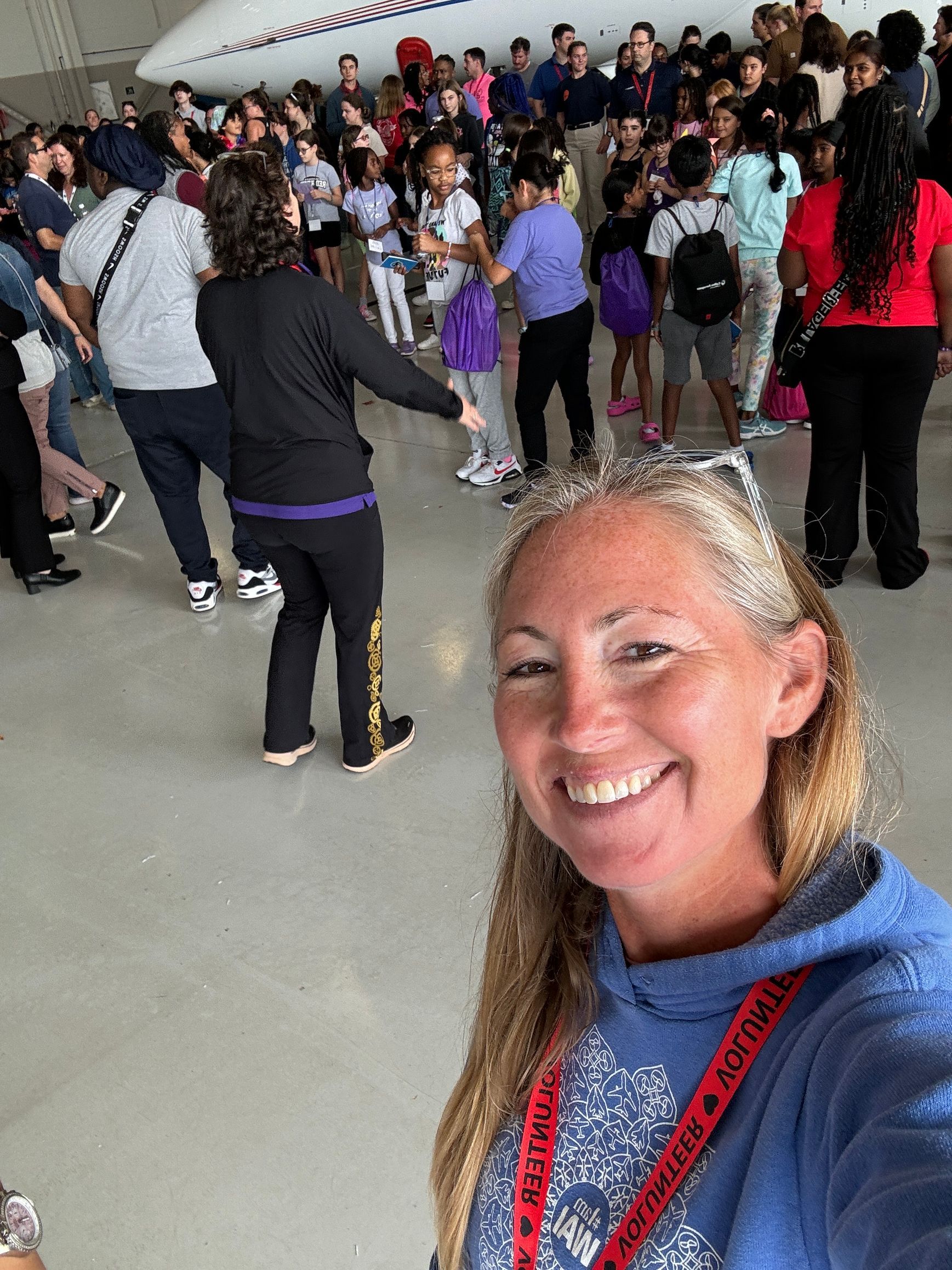 Jessica Power is taking a selfie in front of a crowd of people.