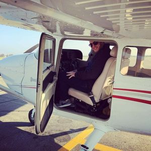 A man is sitting in the cockpit of a small plane