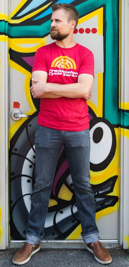 A man standing in front of a door with graffiti on it