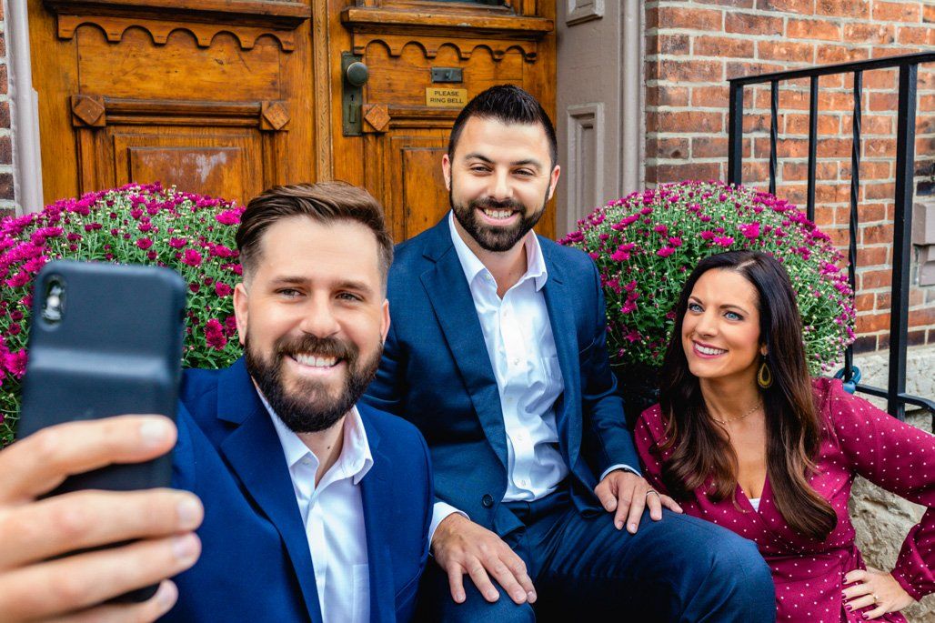 A man is taking a selfie with two other people