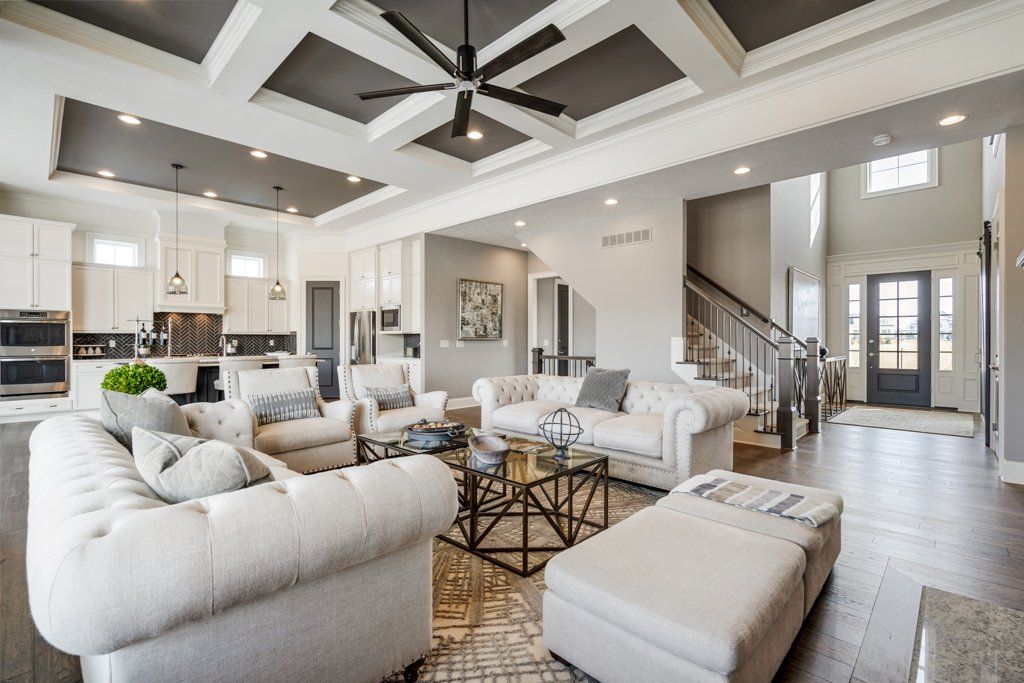 A living room with white furniture and a ceiling fan