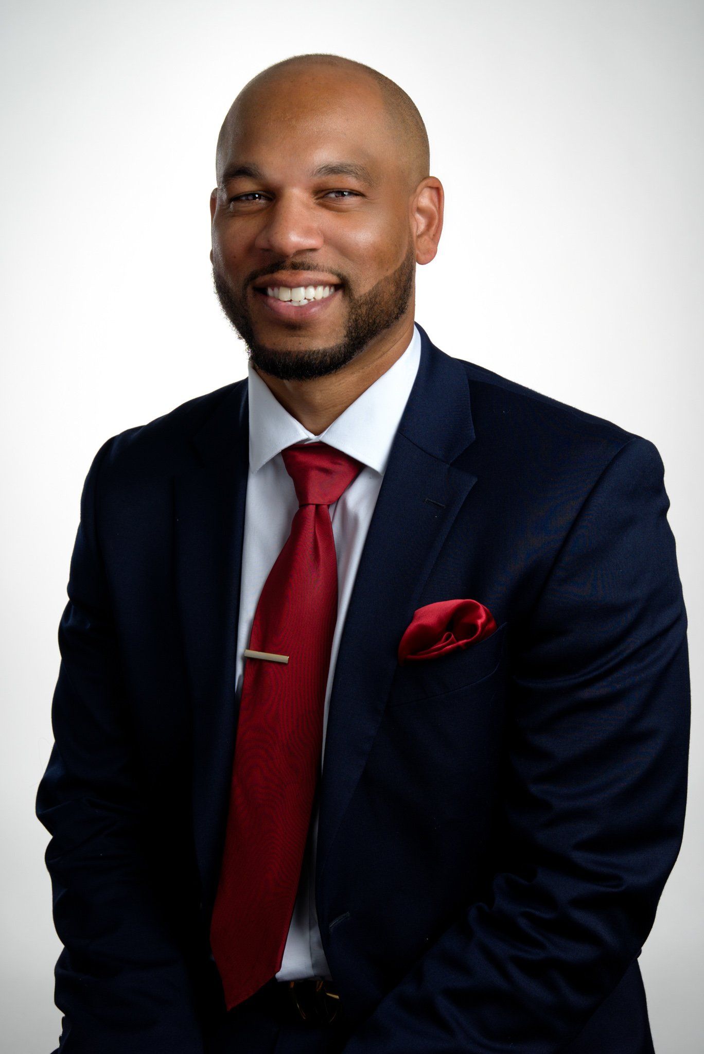 A man in a suit and tie is smiling for the camera