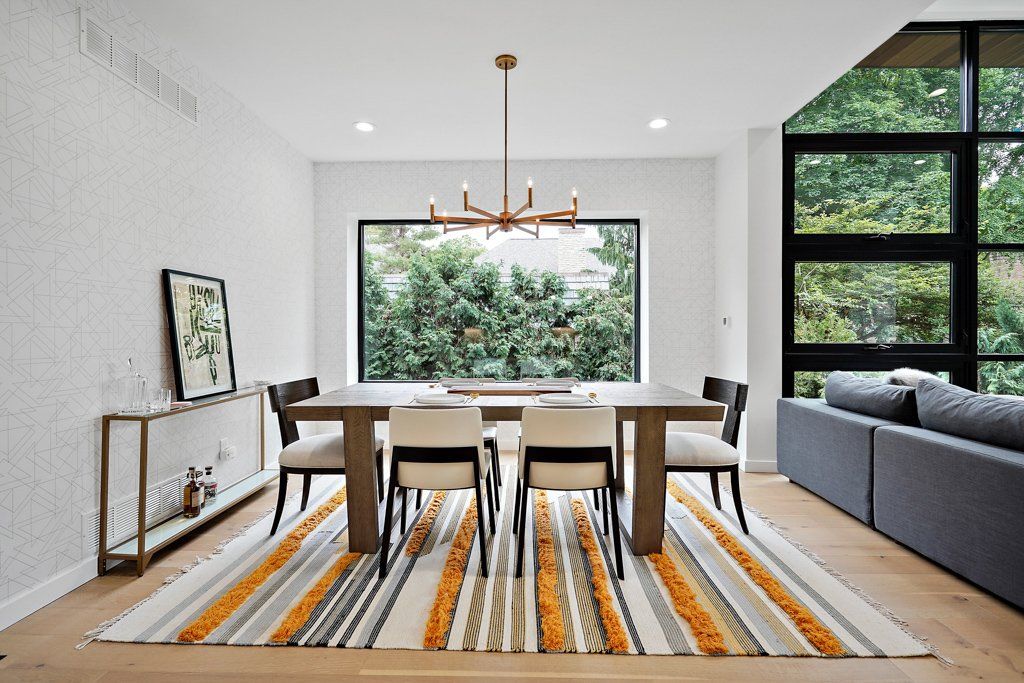 A dining room with a table and chairs and a rug