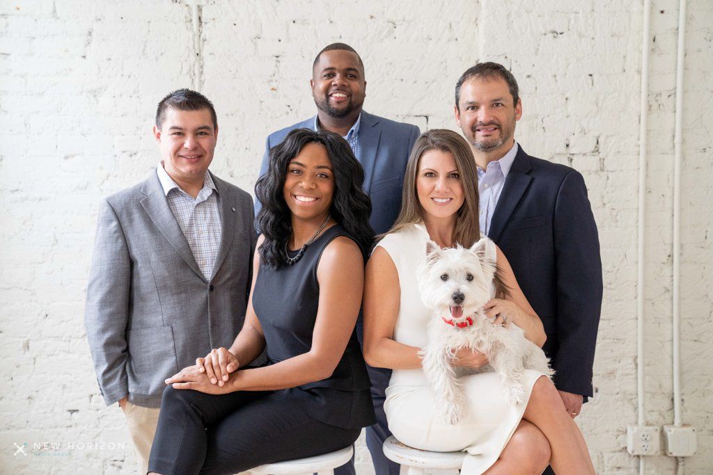 A group of people posing for a picture with a white dog