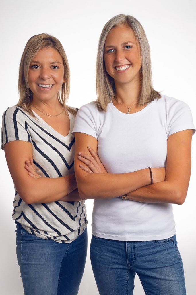 Two women standing next to each other with their arms crossed